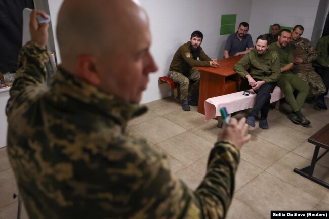 Psychotherapist Oleh Hukovskyi, (foreground) is head of a unit for combat stress control of the 67th Separate Mechanized Brigade. He holds a stress control class in Donetsk region, Ukraine, November 17, 2023. (REUTERS/Sofiia Gatilova)