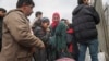 FILE - Syrians wait to cross into Syria near Antakya, Turkey, Feb. 21, 2023. Turkish President Recep Tayyip Erdogan accused opposition parties of stoking racism, July 1, 2024, a day after Syrian-owned shops were set afire in a central Turkey neighborhood.