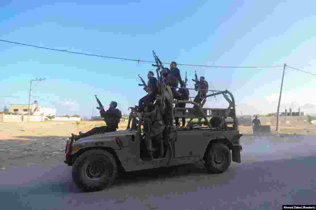 Palestinian militants ride an Israeli military vehicle that was seized by gunmen who infiltrated areas of southern Israel, in the northern Gaza Strip, Oct. 7, 2023.&nbsp;