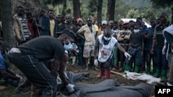Congolese Red Cross volunteers and residents of Nyamukubi wrap in blankets the bodies of people who died in heavy flooding in eastern Democratic Republic of Congo, May 6, 2023. 