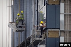 FILE: Para pekerja di lokasi pembangunan gedung apartemen di Beijing, Cina, 29 Juli 2023. (REUTERS/Thomas Peter)