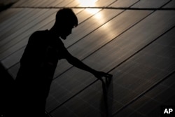 An employee checks solar panels near a hydrogen plant at Oil India Limited in Jorhat, India, on Aug. 17, 2023.
