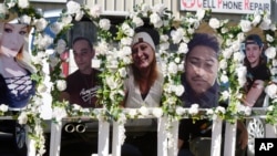 FILE - Photographs of victims of a mass shooting at a nearby gay nightclub are on display at a memorial in Colorado Springs, Colorado, Nov. 22, 2022. 