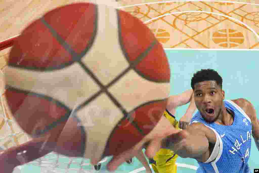 Giannis Antetokounmpo, of Greece, gets a lay-up against Australia in a men's basketball game at the 2024 Summer Olympics, in Villeneuve-d'Ascq, France. 