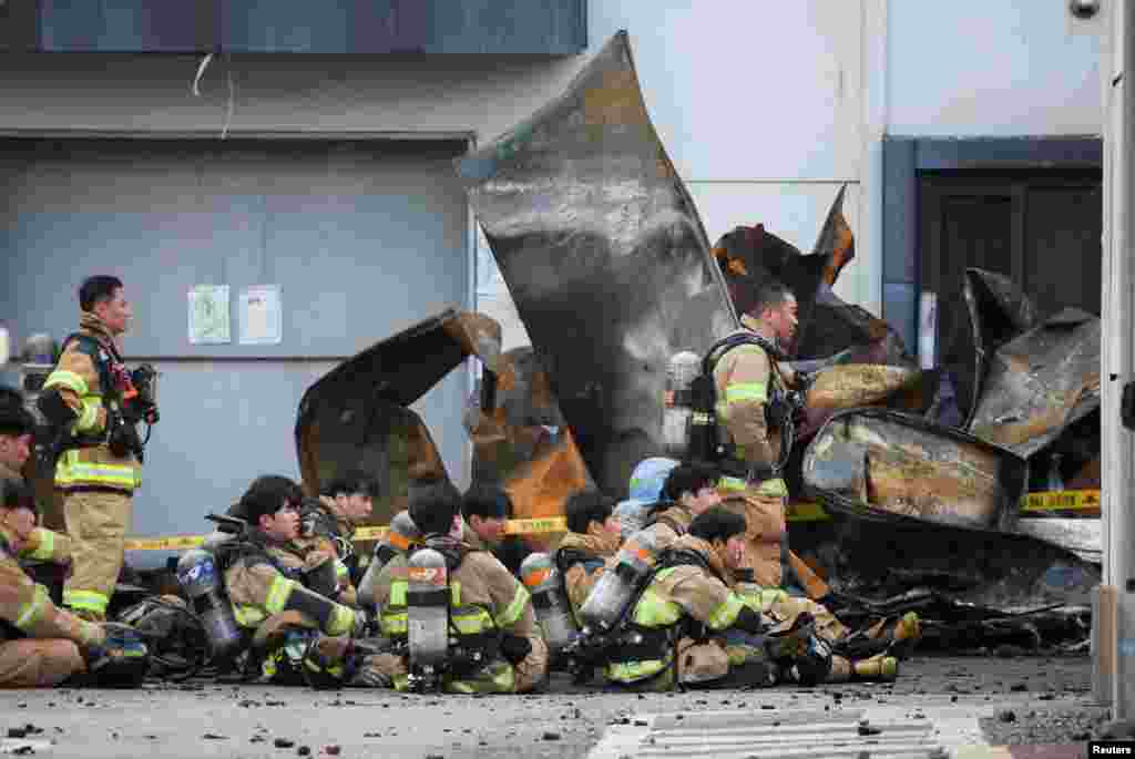 Firefighters take a break as rescue work continues following a deadly fire at a lithium battery factory owned by South Korean battery maker Aricell, in Hwaseong, South Korea.