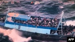 Potongan gambar dari sebuah video yang dirilis pada 11 Maret 2023 ini menunjukkan sebuah kapal yang disesaki oleh para migran terombang-ambing di lepas pantai Calabria, Italia, pada 10 Maret 2023. (Foto: Handout/Guardia Costiera/AFP)