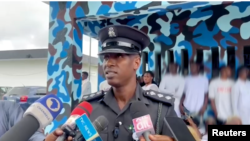 In this image taken from video, Bright Edafe, the Delta state police spokesman in Nigeria, speaks to reporters after parading 67 detainees (faces blurred by source) in public in the town of Ekpan on Aug. 29, 2023. (TVC via Reuters)