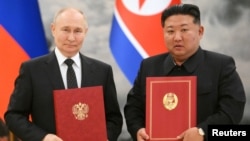 Presiden Rusia Vladimir Putin dan pemimpin Korea Utara Kim Jong-un, berpose usai menandatangani pakta pertahanan bersama di Pyongyang, Rabu (19/6). 