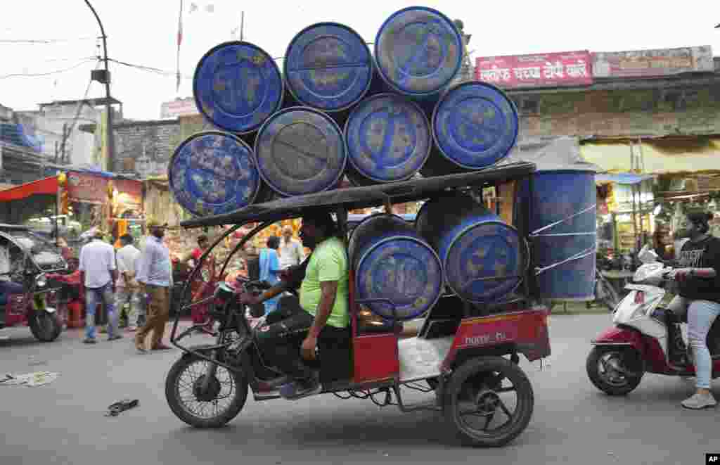 An electric rickshaw carries barrels in Prayagraj, in the northern Indian state of Uttar Pradesh.