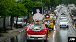 A hearse carrying the coffin of the late Myanmar general turned democracy activist Tin Oo makes its way to the cemetery during his funeral in Yangon, June 5, 2024. 