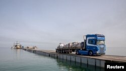 資料照片：一輛卡車通過加沙沿海的臨時碼頭運送援助物資。(2024年5月19日）