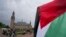 A demonstrator waves the Palestinian flag outside the Peace Palace housing the International Court of Justice in The Hague, Netherlands, May 24, 2024. The U.N. court ordered Israel to halt its military operations in Gaza.