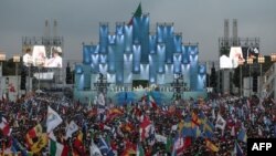 Para peziarah menghadiri misa pembukaan Hari Pemuda Sedunia, festival remaja Katolik di Eduardo VII Park di Lisbon, Portugal, Kamis, 1 Agustus 2023. (Foto: Thomas Coex/AFP)