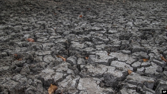 FILE - Cracked earth is all that remains of what was the bottom of a cattle watering hole in Mudzi, Zimbabwe, on July 2, 2024. In Zimbabwe and across Southern Africa, an El Nino-induced drought is affecting millions of people.