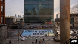 Aktivis dari Greenpeace memasang spanduk di luar markas besar PBB selama negosiasi perjanjian untuk melindungi kehidupan alam di laut lepas di New York, AS (foto: dok). 