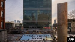 Плакат Greenpeace с требованием незамедлительного принятия соглашения по защите Мирового океана перед зданием штаб-квартиры ООН