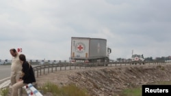 Vehicles of the International Committee of the Red Cross filled with humanitarian aid for residents of Nagorno-Karabakh drive toward the Armenia-Azerbaijan border along a road near the village of Kornidzor, Armenia, Sept. 23, 2023. 