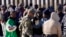 FILE - A member of US Customs and Border Protection tries to control a group of migrants as hundreds gather along the border after breaking through gaps in the border wall Dec. 5, 2023, in Lukeville, Ariz. 