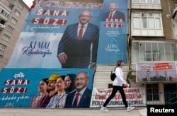 Seseorang berjalan melewati baliho kampanye pemilihan Kemal Kilicdaroglu, kandidat presiden dari aliansi oposisi utama Turki menjelang pemilihan putaran kedua 28 Mei, di Ankara, Turki, 26 Mei 2023. (Foto: Reuters)