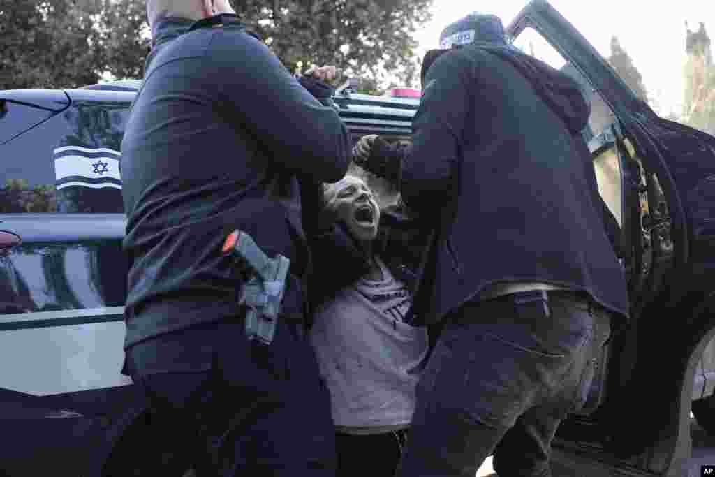 Police detain an anti-government protester who blocked an entrance to the Knesset, Israel&#39;s parliament in Jerusalem.