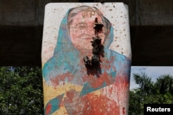 Sebuah mural Perdana Menteri Bangladesh Sheikh Hasina dirusak oleh pengunjuk rasa, sehari setelah pengunduran dirinya, di Dhaka, Bangladesh, 6 Agustus 2024. (Foto: REUTERS/Mohammad Ponir Hossain)