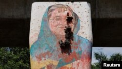 Lukisan mural PM Bangladesh Sheikh Hasina dirusak oleh pengunjuk rasa, sehari setelah pengunduran dirinya, di Dhaka 6 Agustus 2024.