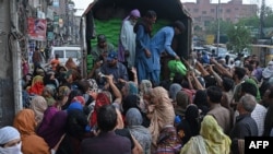 Orang-orang berkumpul untuk menerima tepung gratis menjelang bulan suci Ramadan, di Lahore pada 20 Maret 2023. (Foto: AFP)