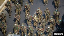 Tentara Myanmar berjalan di sepanjang jalan selama protes menentang kudeta militer di Yangon, Myanmar, 28 Februari 2021. (Foto: Reuters)