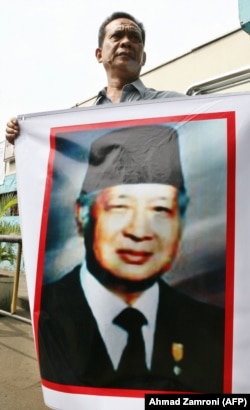 Seorang pendukung mantan presiden Soeharto memegang spanduk bergambar dirinya di luar RS Pertamina di Jakarta, 12 Januari 2008. (Foto: AFP/Ahmad Zamroni)