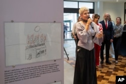 Katya Taylor is curator of the War Diaries exhibition, which showcases the personal diaries of Ukrainian children who have witnessed the war. (AP Photo/Peter Dejong)