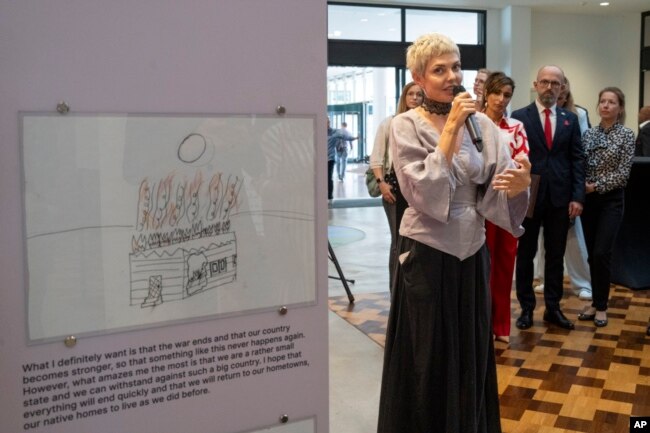 Katya Taylor is curator of the War Diaries exhibition, which showcases the personal diaries of Ukrainian children who have witnessed the war. (AP Photo/Peter Dejong)