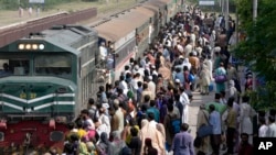 People board a passenger train to reach their villages and cities to celebrate the upcoming Eid al-Fitr holidays, marking the end of the Islamic holy month of Ramadan, in Lahore, Pakistan, April 20, 2023.