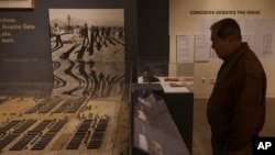 Ron Wakabayashi, former head of the Los Angeles County Human Relations Committee, looks at a model of the Manzanar War Relocation Center at the Japanese American National Museum in Los Angeles, Feb. 11, 2023. 