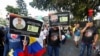 ARCHIVO- Personas protestan frente al estadio Alfonso López antes del partido final de la Copa América Femenina, en contra de los asesinatos de policías por parte de la banda criminal Clan Del Golfo, según las autoridades, en Bucaramanga, Colombia, en julio de 2022.