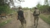 Ukrainian soldiers walk through the combat zone in Storozheve, Ukraine, June 23, 2023.