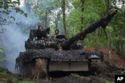 Tentara Ukraina menaiki tank di sepanjang jalan menuju posisi mereka di dekat Bakhmut, wilayah Donetsk, Ukraina. (Foto: via AP)