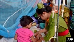 বাংলাদেশের ঢাকার একটি সরকারি হাসপাতালে ডেঙ্গু জ্বরে আক্রান্ত একটি শিশুর পরিচর্যা করছেন একজন নার্স। (ফাইল ছবি) 