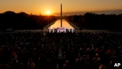 FILE - The word "Jesus" is displayed on a large monitor and worship songs are played on stage as people gather for the Easter sunrise service at the Lincoln Memorial, April 9, 2023, in Washington.