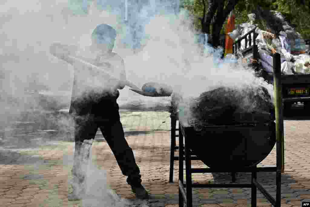 A police officer burns 1.2 tons of seized marijuana and 226 kilograms of methamphetamine at the regional police headquarters in Banda Aceh, Indonesia.