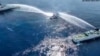 Kapal Penjaga Pantai Filipina BRP Bagacay (tengah) terkena meriam air dari kapal penjaga pantai China di dekat perairan Scarborough yang dikuasai China di perairan sengketa Laut China Selatan. (Foto: via AFP)