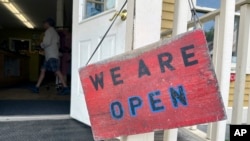A sign hangs on the front door of Kingdom Trails in Burke, Vt., Aug. 14, 2024. Storms that hit the region on July 10 and July 30 washed away some roads and bridges, damaged homes and trails, and discouraged visitors at the height of the season.