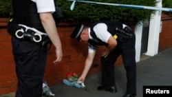 A police officer places flowers, given by residents, behind the police cordon near the scene of a stabbing incident in Southport, Britain, July 29, 2024.