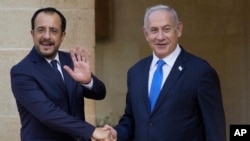 Israeli Prime Minister Benjamin Netanyahu, right, and Cypriot President Nikos Christodoulides shake hands before their meeting at the presidential palace in the capital Nicosia, Cyprus, Sept. 3, 2023.