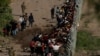 Migrantes que buscan asilo, en su mayoría de Venezuela y Cuba, son detenidos por agentes de Aduanas y Protección Fronteriza de Estados Unidos después de cruzar el río Bravo hacia EEUU desde México en Eagle Pass, Texas, el 13 de julio de 2022.