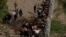 Migrantes que buscan asilo, en su mayoría de Venezuela y Cuba, son detenidos por agentes de Aduanas y Protección Fronteriza de Estados Unidos después de cruzar el río Bravo hacia EEUU desde México en Eagle Pass, Texas, el 13 de julio de 2022.