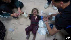 FILE - Palestinian medics treat a wounded baby at Al Aqsa Hospital in Deir al-Balah, Gaza Strip, May 11, 2024. U.S. officials are working to get upward of 20 American doctors and medical workers who The Intercept reports are trapped in Gaza.  