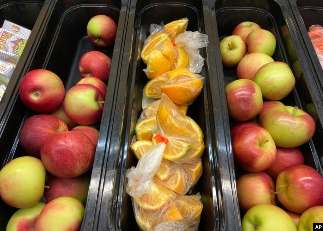 FILE - Apples and orange slices rest in trays for student lunch at the Albert D. Lawton Intermediate School, in Essex Junction, Vt., Thursday, June 9, 2022. (AP Photo/Lisa Rathke)