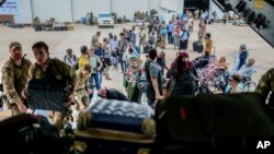 British nationals prepare to board a Royal Air Force aircraft at Wadi Seidna Air Base, Sudan, April 27, 2023. The U.N. relocated hundreds of staff from Khartoum and the western Darfur region to Port Sudan in the east this week. (UK Ministry of Defence via AP)