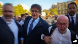 Pemimpin kemerdekaan Catalan dan mantan Presiden Carles Puigdemont, (tengah), tiba untuk berpidato di depan pendukungnya di Barcelona, ​​Spanyol, 8 Agustus 2024. (Foto: Emilio Morenatti/AP Photo)