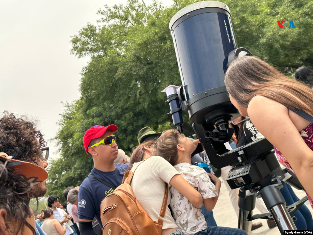 Familias enteras se dan cita en la explanada de la Universidad Autónoma de Nuevo León (UANL), en México, para observar el eclipse de sol que se visualizó en la región en un 95 %.